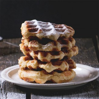 Photo: A stack of belgian waffles dusted with powdered sugar