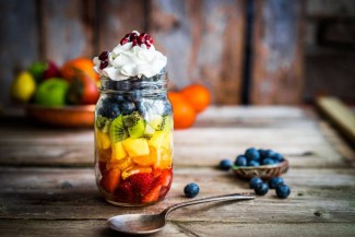 Photo: Jar of cut fruit topped with cream and seeds