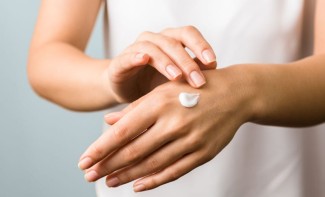 Photo: Woman applying hand lotion