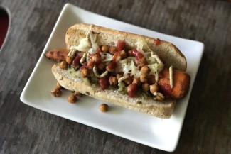 Photo: Large roasted carrot with toppings in a hot dog bun