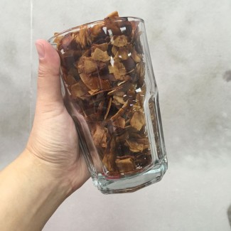 Photo: Person holding a glass of coconut strips 