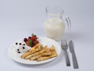 Eggless french toast served on a white plate with a jug of milk