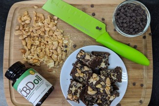 Photo: Peanuts, Chocolate Chips and CBD Oil on a Cutting Board