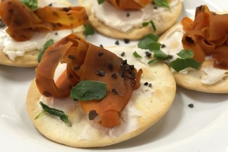 Photo: Smoked carrot strips on top of cracker with cream cheese and garnishes