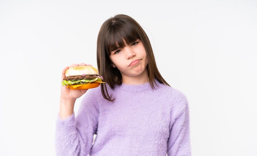 Photo: GIrl Frowning and Holding a Burger