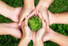 Photo Illustration: Hands holding green earth together