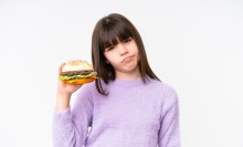 Photo: GIrl Frowning and Holding a Burger