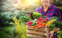 Photo: Woman holding a box of vegetables